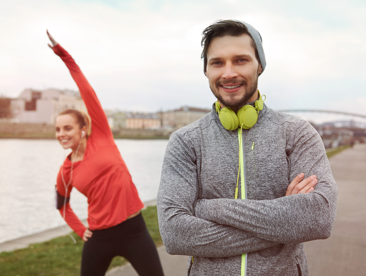 Te veel sporten Man en vrouw zijn buiten aan het rekken en strekken als opwarming voor hun hardloopsessie waarbij ze schuldig zijn aan te veel sporten
