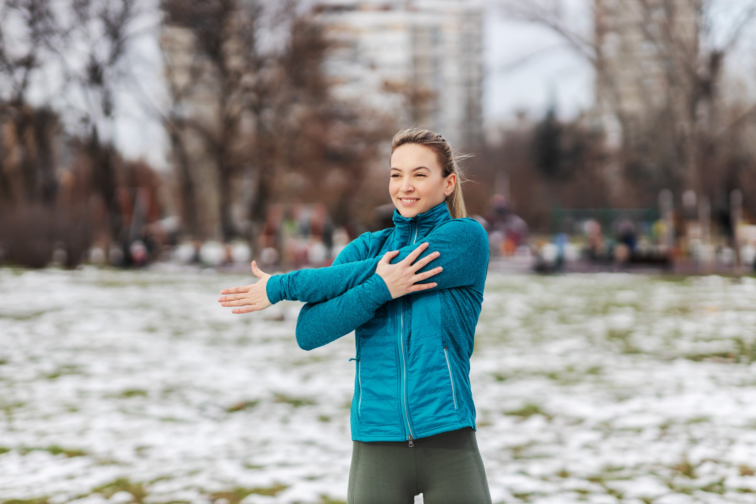 Vrouw in blauw vest rekt zich uit om te gaan sporten voor een positievere mindset.